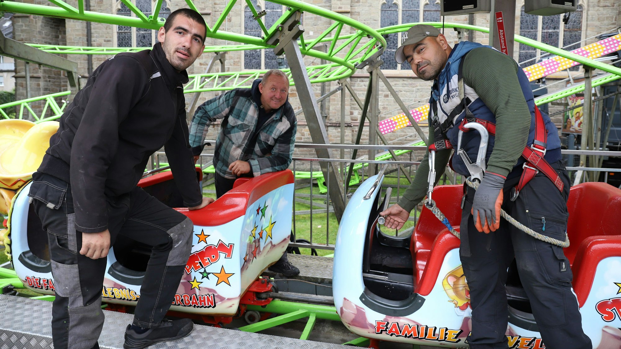 Victor Gusanu (l.) und Claudio Johann nehmen ihren Chef Marco Welte in die Mitte, sie bauen gerade die Achterbahn „Speedy“ auf.