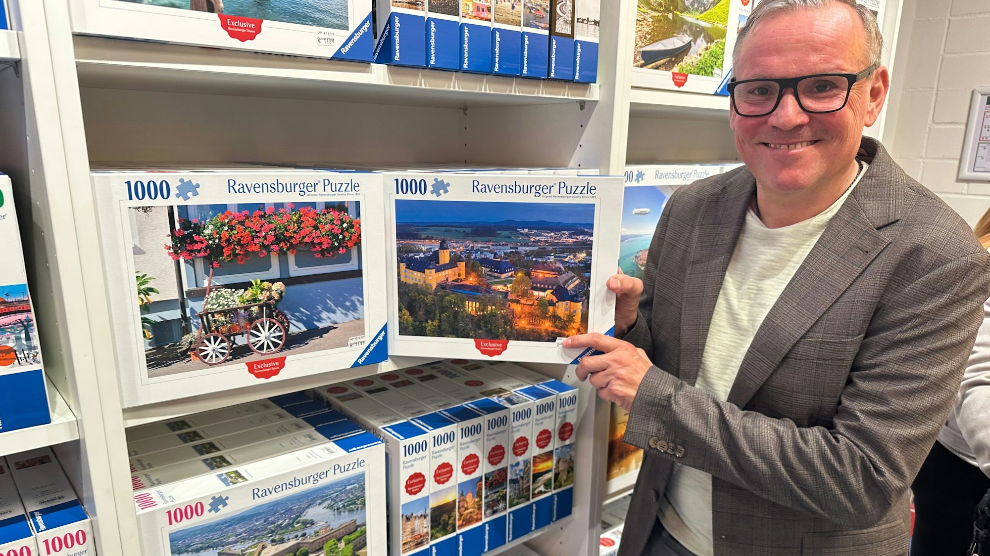 Geschäftsführer Rainer Hartel zeigt ein Puzzle mit dem Schloss von Montabaur, das im dortigen Outlet angeboten wird. Motive aus dem Rhein-Sieg-Kreis kommen bald im Shop im Huma hinzu.