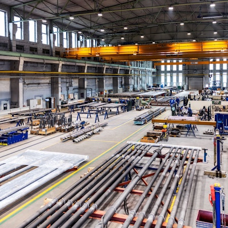 Blick in eine Produktionshalle, in der Rohre geschweißt werden.