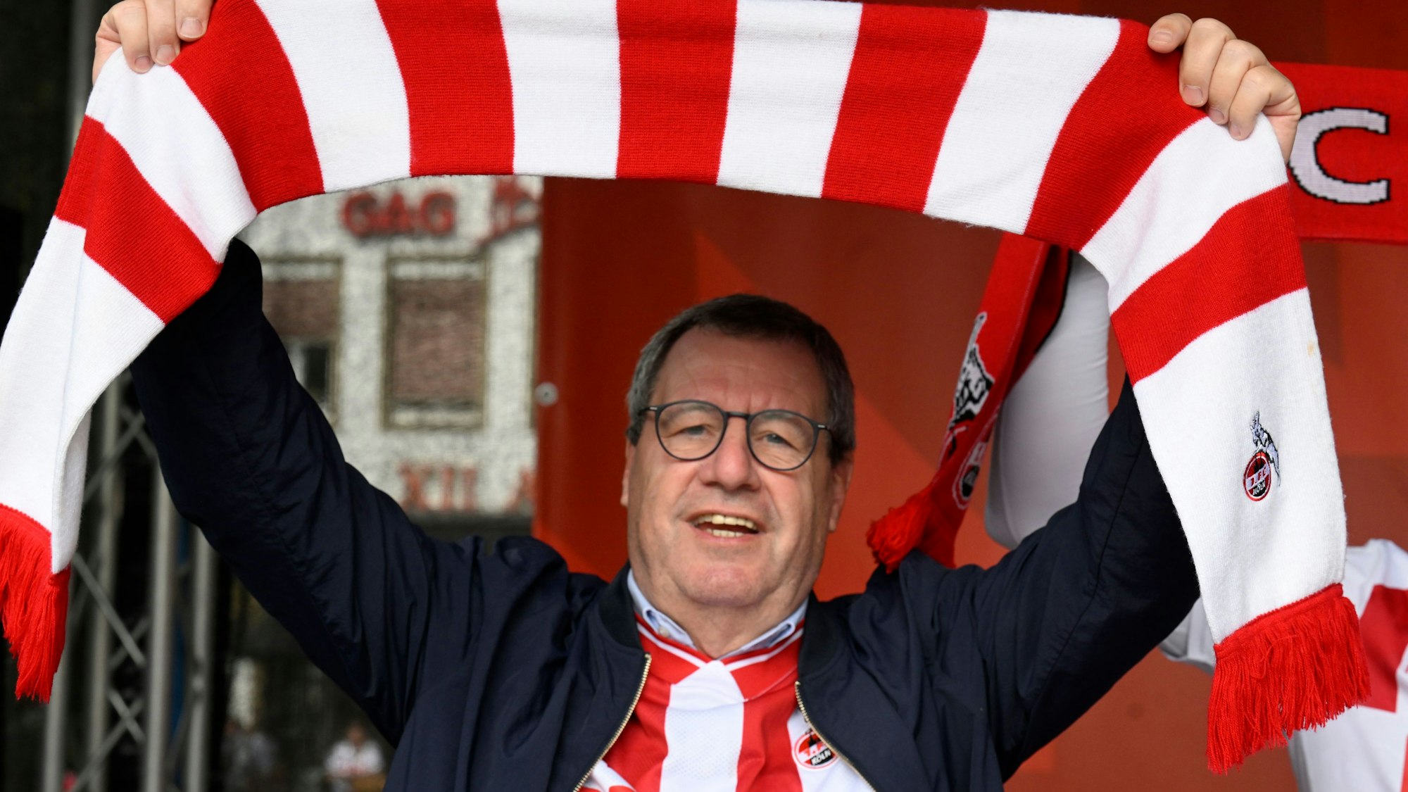 ARCHIV - 31.08.2025, Nordrhein-Westfalen, Köln: Werner Wolf, Präsident des Fussball-Bundesligisten 1. FC Köln, hält bei einer Demonstration auf dem Heumarkt für die Erweiterung des Geissbockheims einen Fan-Schal. Die Stadt verhindert seit Jahren den Ausbau des Trainingsgeländes des Vereins an den Gleueler Wiesen. (zu dpa: ««Achterbahnfahrt»: Wolf verabschiedet sich als FC-Präsident») Foto: Roberto Pfeil/dpa +++ dpa-Bildfunk +++