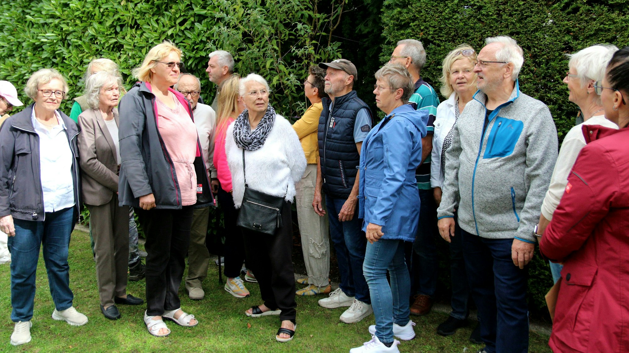 Zu sehen ist eine Gruppe von Menschen im Grünen.