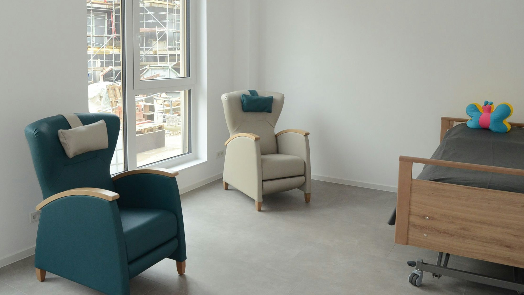 Zwei Sessel und ein Bett in einem Zimmer.