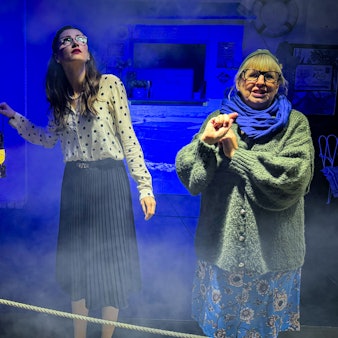 Zwei Frauen stehen auf einer Bühne.