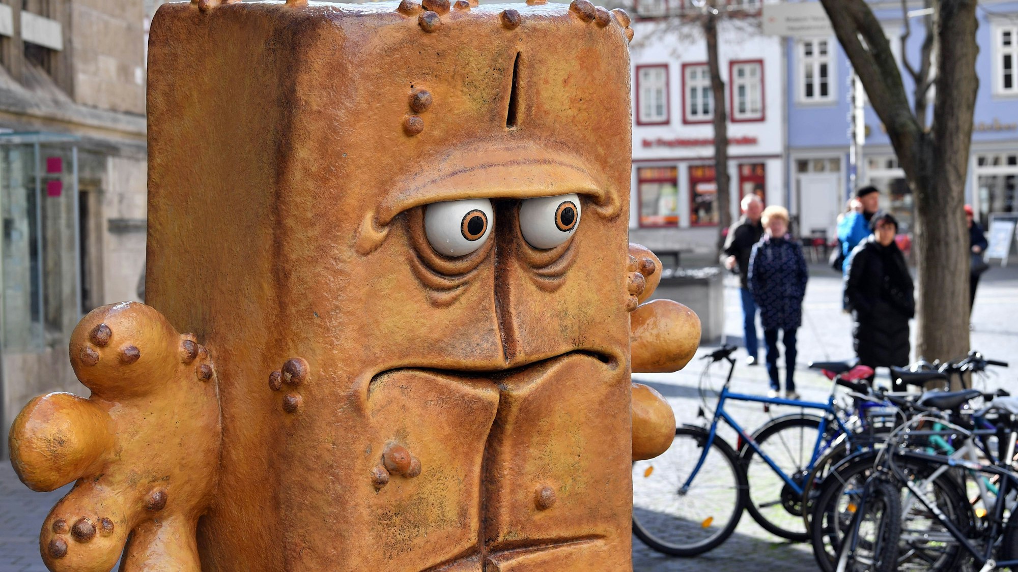 ARCHIV - 13.03.2020, Thüringen, Erfurt: Passanten laufen hinter der Figur «Bernd das Brot» aus dem Kinderfernsehen neben dem Rathaus am Fischmarkt entlang.
(zu dpa: «Großer Auftritt für Bernd das Brot in US-Satire-Talkshow») Foto: Martin Schutt/dpa-Zentralbild/dpa +++ dpa-Bildfunk +++