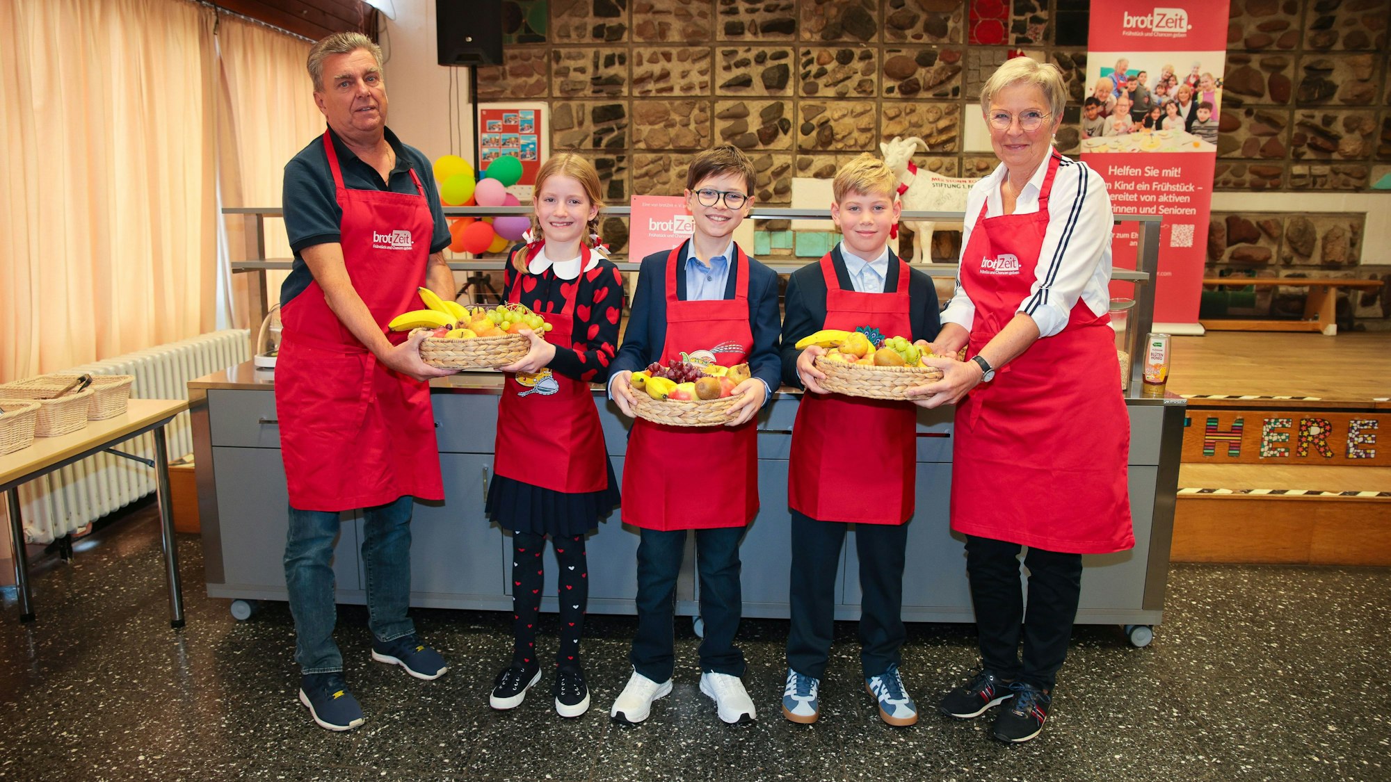 Das Kölner Kinderdreigestirn übergibt Obstkörbe.