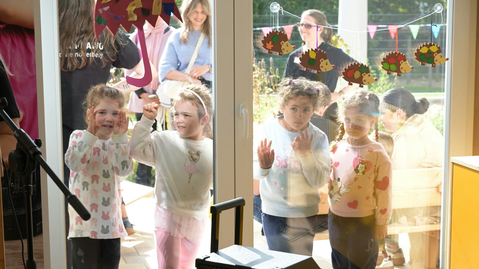 Vier Mädchen stehen hinter der Fensterscheibe.