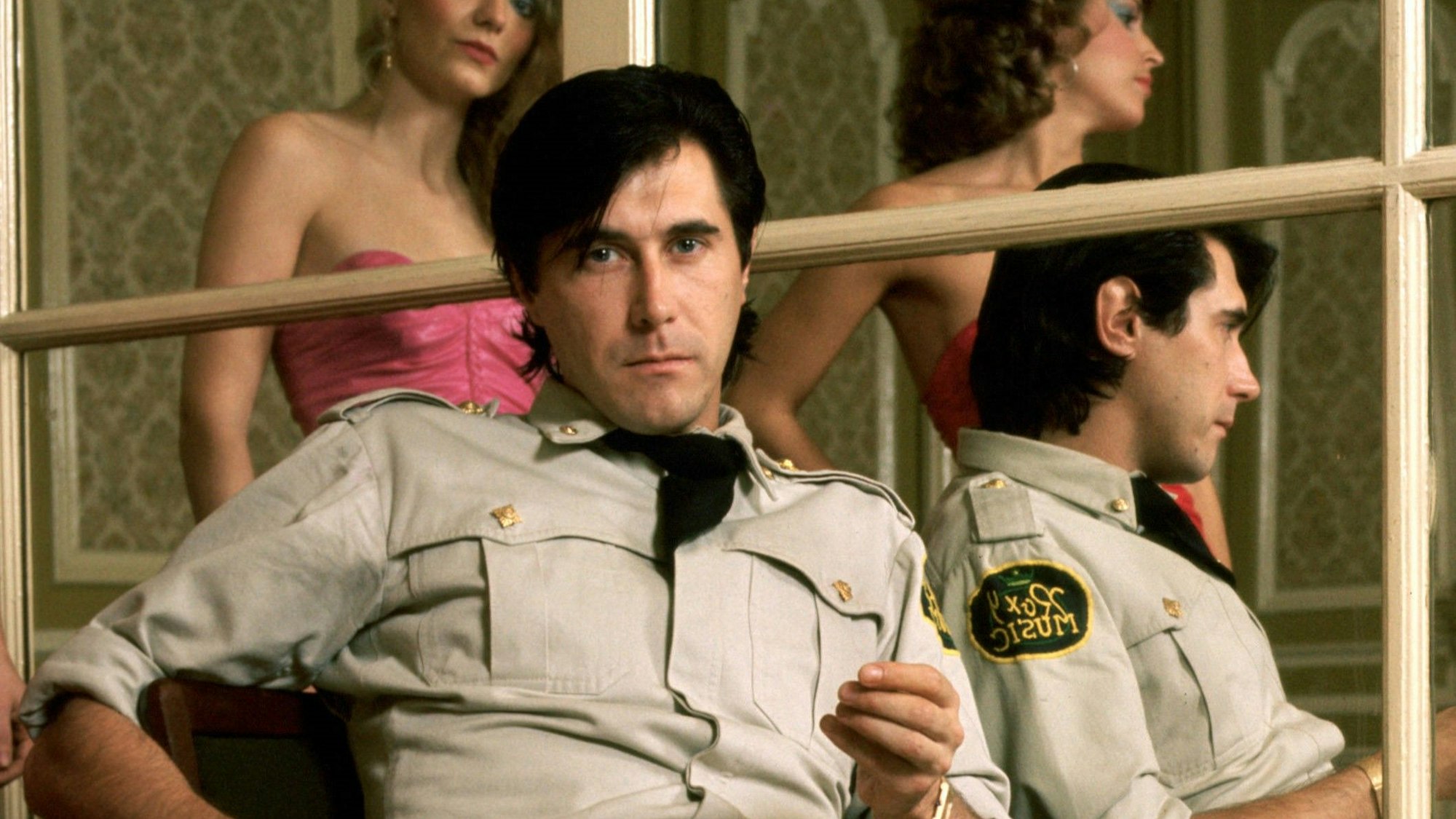 Bryan Ferry sitzt in einem Raum.