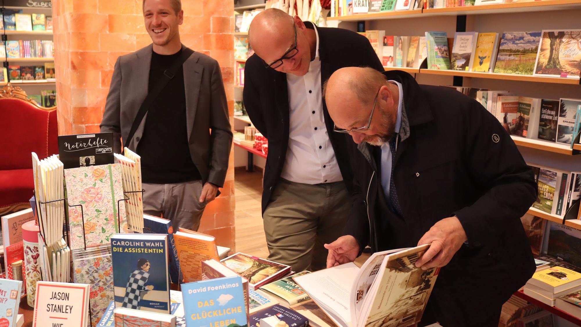 Martin Schulz blättert im Bildband "Münstereifel im Jahr 1900". Neben ihm Bürgermeisterkandidat Sebastian Glatzel. Im Hintergrund lacht Landrat Markus Ramers.