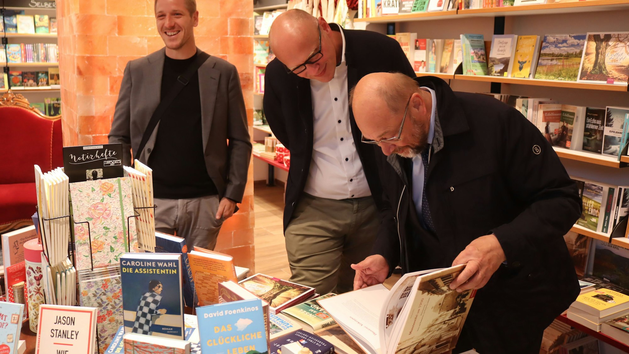 Martin Schulz blättert im Bildband "Münstereifel im Jahr 1900". Neben ihm Bürgermeisterkandidat Sebastian Glatzel. Im Hintergrund lacht Landrat Markus Ramers.