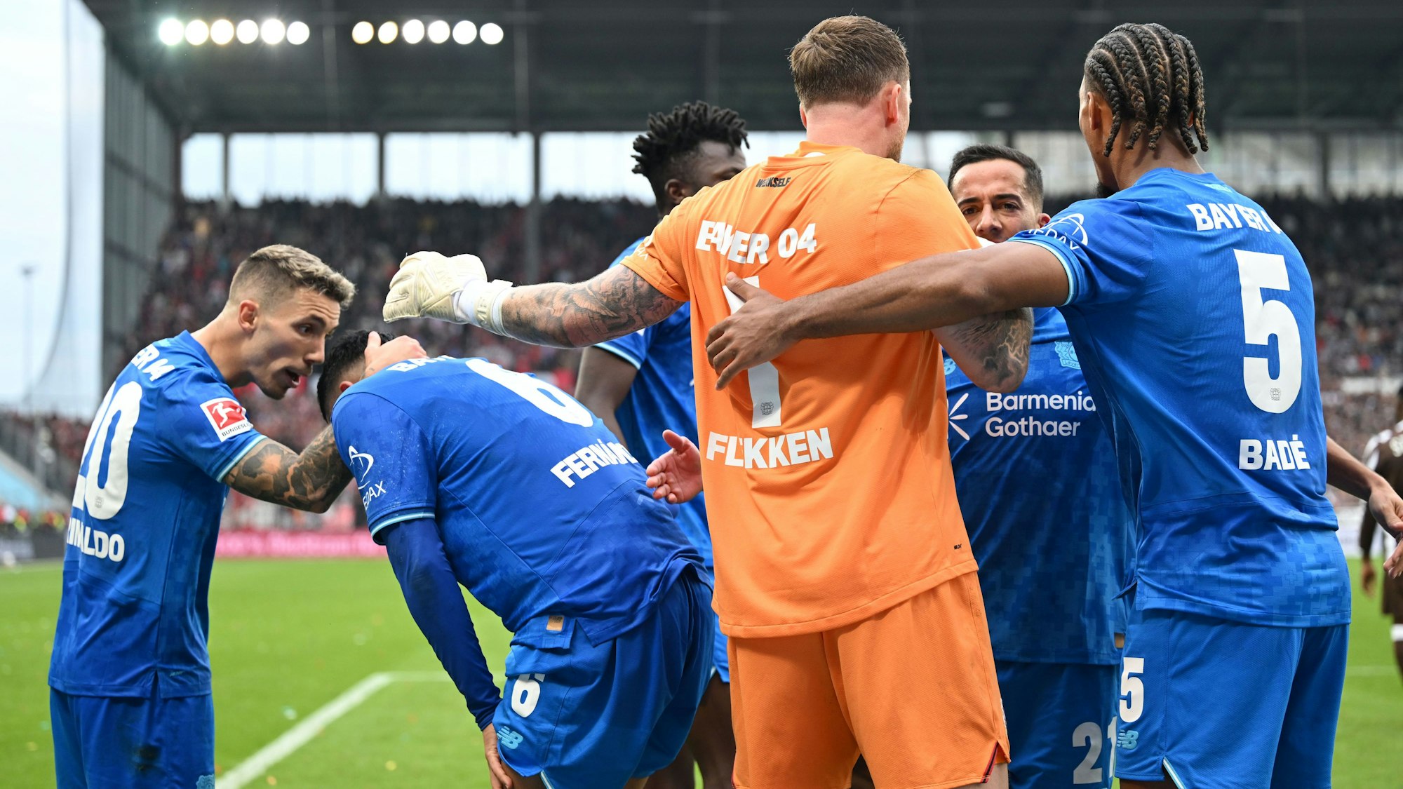 27.09.2025, Hamburg: Fußball: Bundesliga, FC St. Pauli - Bayer Leverkusen, 5. Spieltag, Millerntor-Stadion. Torwart Mark Flekken (Bayer Leverkusen) jubelt nach dem Abpfiff unter anderem mit Álex Grimaldo (Bayer Leverkusen),Edmond Tapsoba (Bayer Leverkusen). Foto: Carmen Jaspersen/dpa - WICHTIGER HINWEIS: Gemäß den Vorgaben der DFL Deutsche Fußball Liga bzw. des DFB Deutscher Fußball-Bund ist es untersagt, in dem Stadion und/oder vom Spiel angefertigte Fotoaufnahmen in Form von Sequenzbildern und/oder videoähnlichen Fotostrecken zu verwerten bzw. verwerten zu lassen. +++ dpa-Bildfunk +++