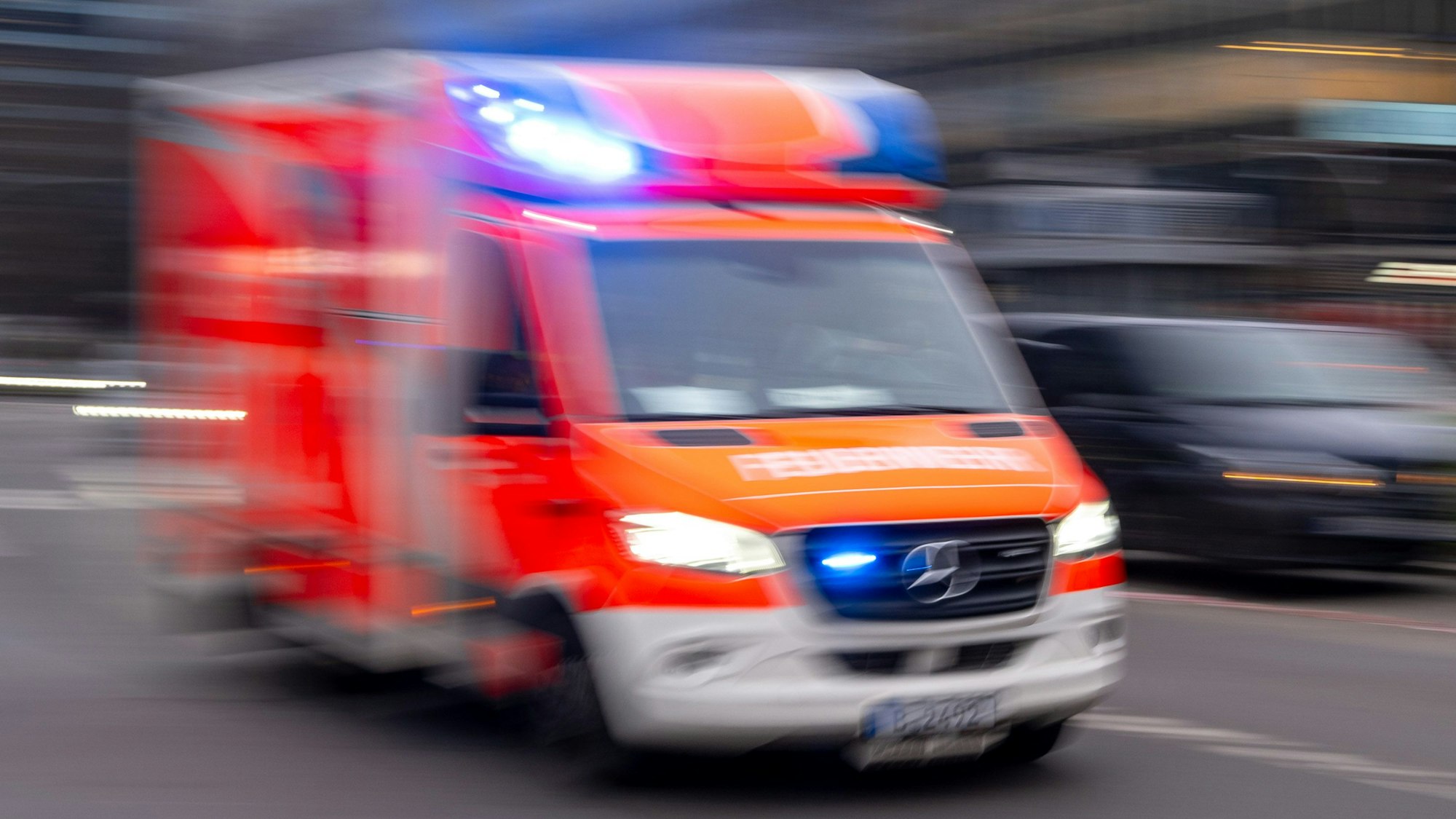 Ein Rettungswagen der Feuerwehr fährt mit Blaulicht.