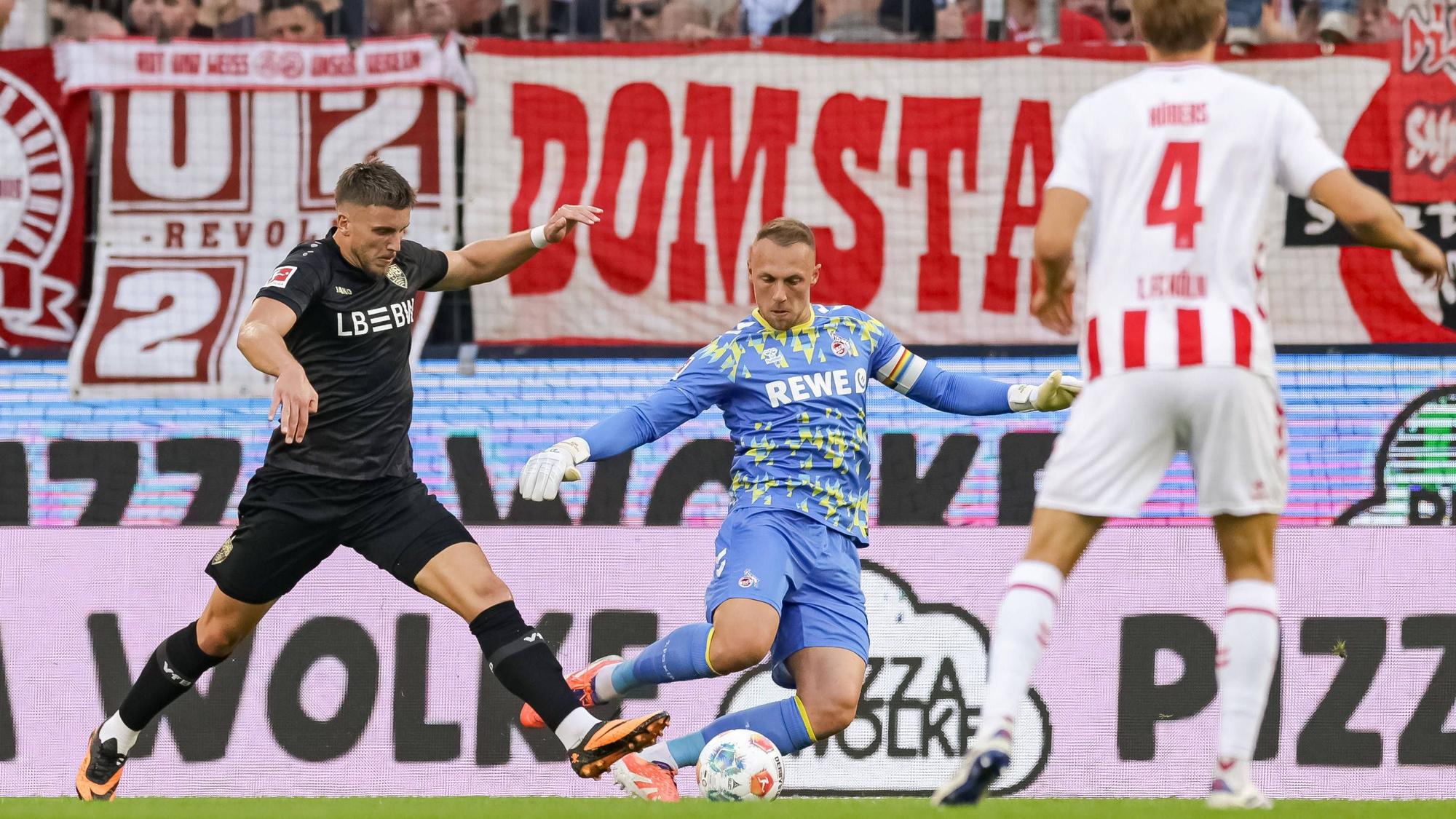 Ermedin Demirovic ist vor Marvin Schwäbe am Ball, der Kölner Torwart klärt auf Kosten eines Elfmeters.