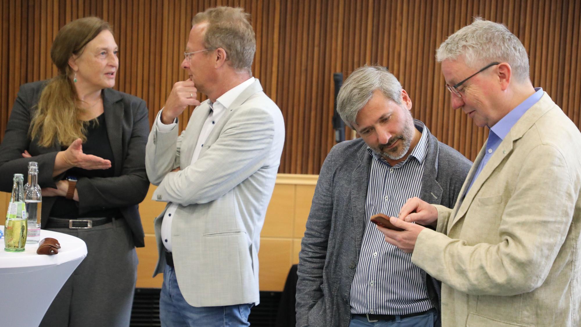 Grünen-Politiker sprechen am Stichwahl-Abend (28.9.2025) im Kreishaus des Rheinisch-Bergischen Kreises miteinander.