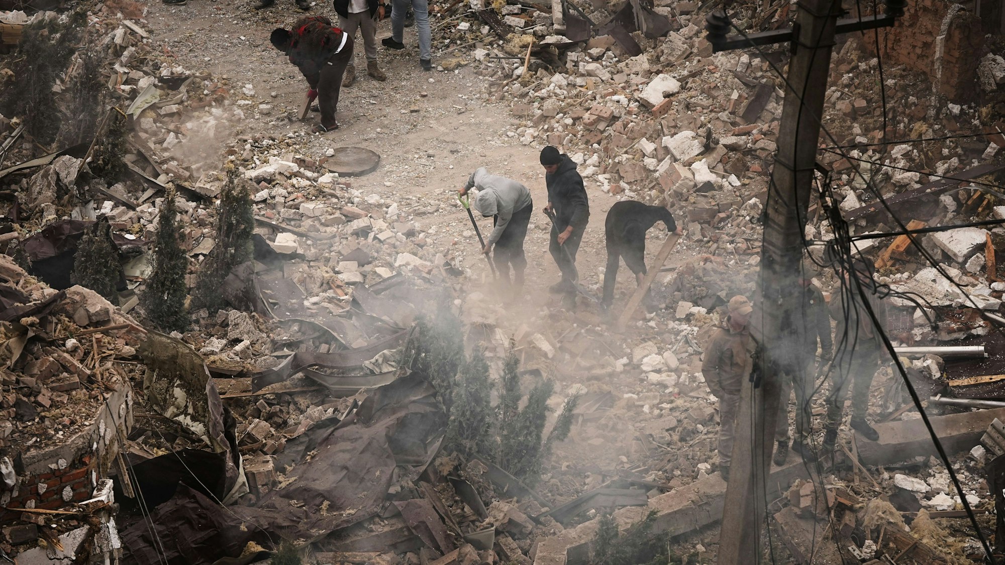 Menschen räumen die Trümmer eines Wohnhauses weg, das bei einem russischen Angriff in Kiew beschädigt wurde.