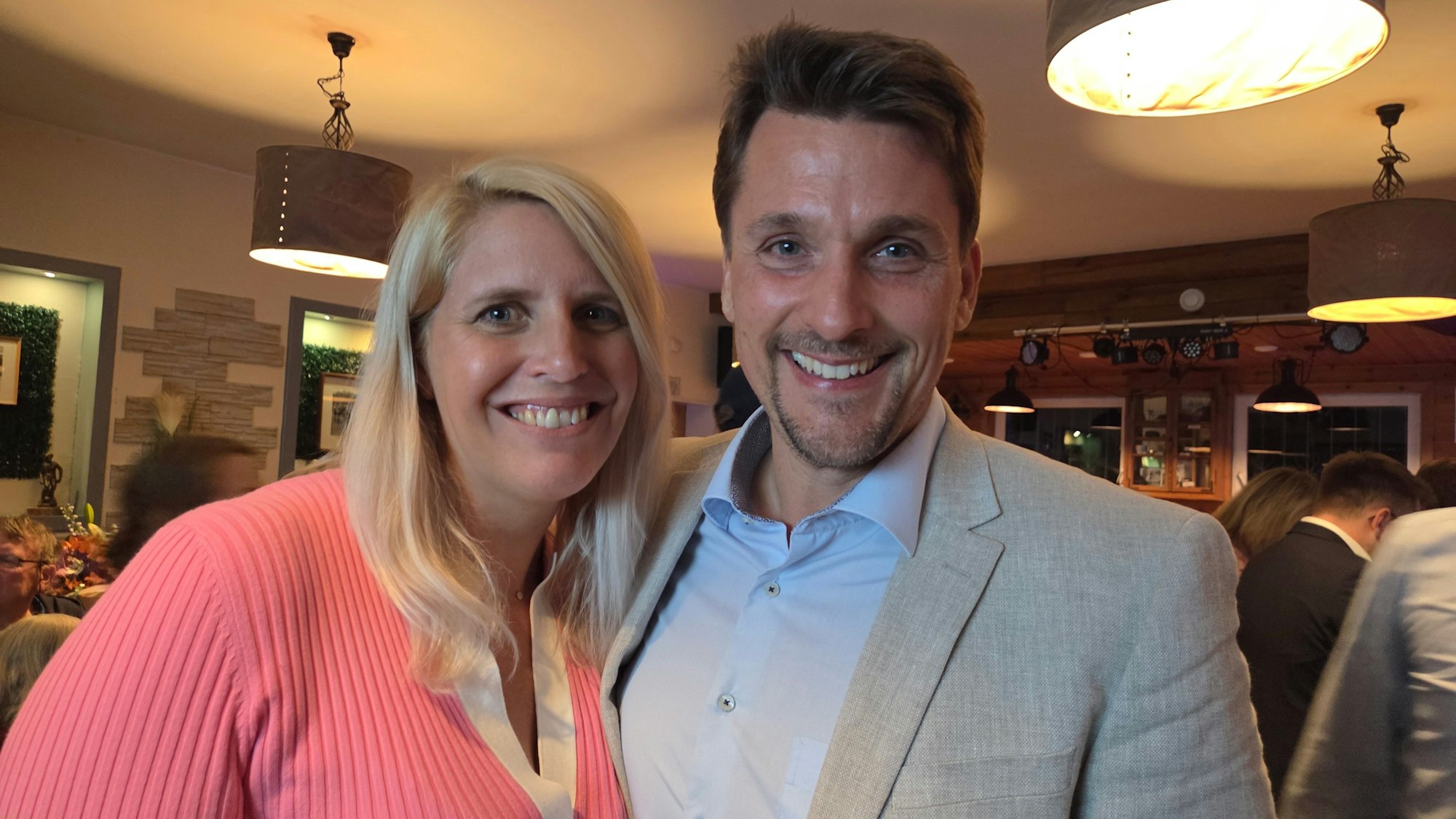 Ein Mann und eine Frau lachen in die Kamera.