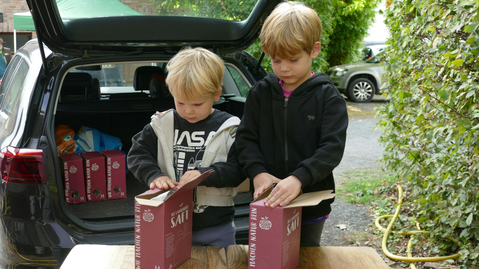 In Tüten abgefüllt können Till (4) und Paul (6) ihren Apfelsaft mit nach Hause nehmen.