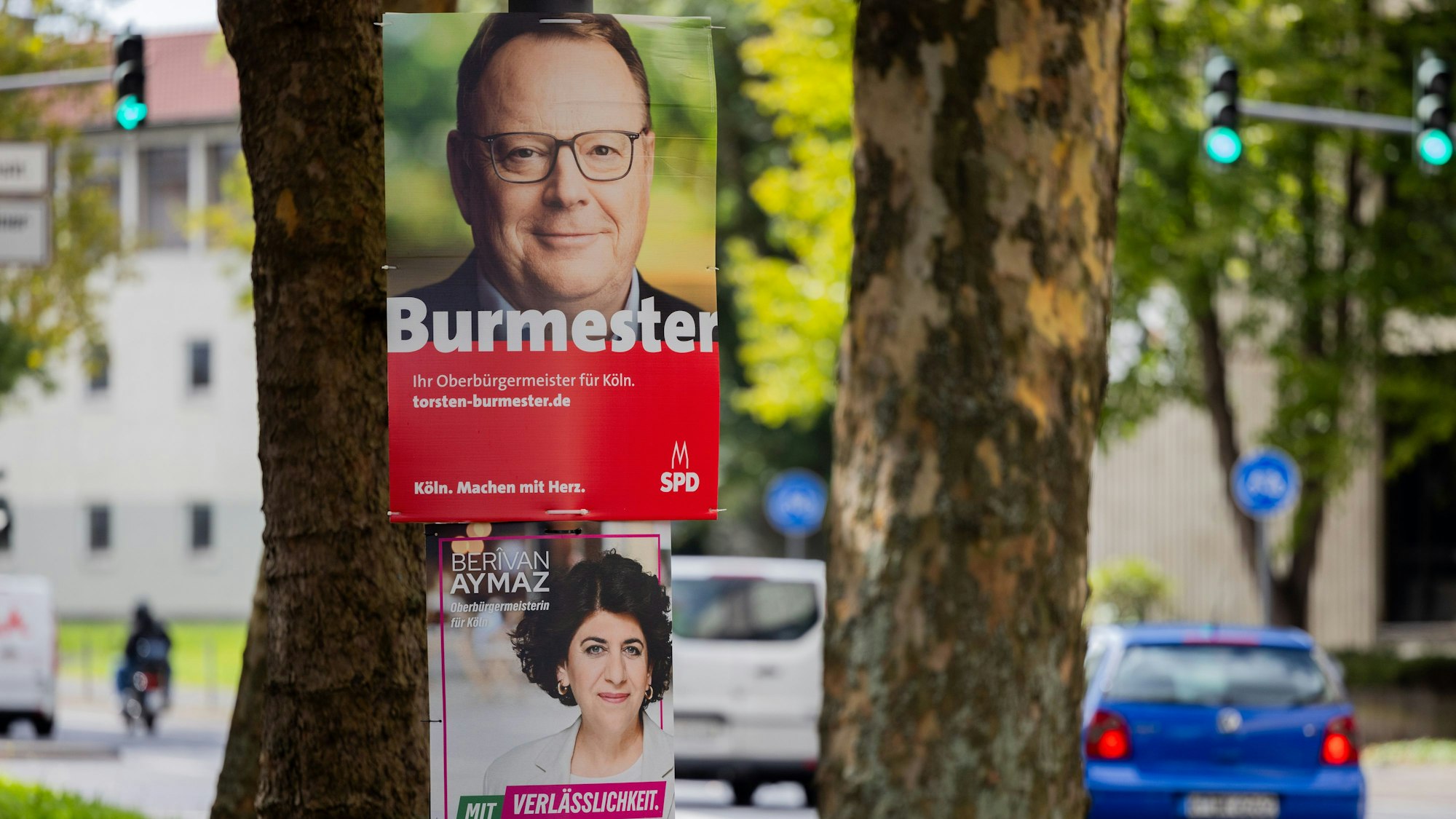 Köln: Zwei Wahkplakate zeigen die beiden Kandidaten von SPD, Torsten Burmester (oben), und von Bündnis 90/Die Grünen, Berivan Aymaz. Der SPD-Kandidat setzte sich am Sonntag (28. September) durch.