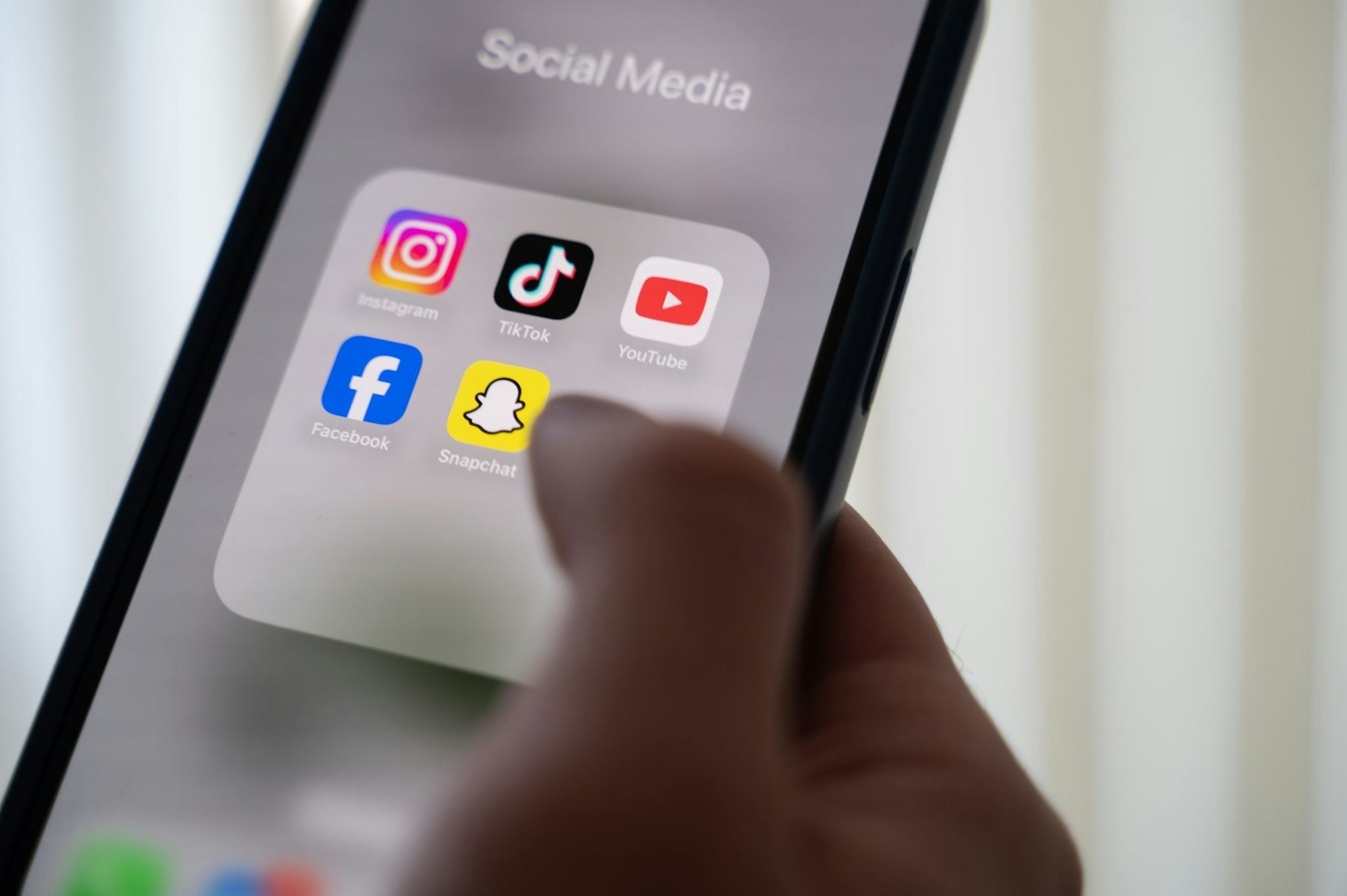 Das Display auf einem Smartphone zeigt verschiedene Social Media Apps an.