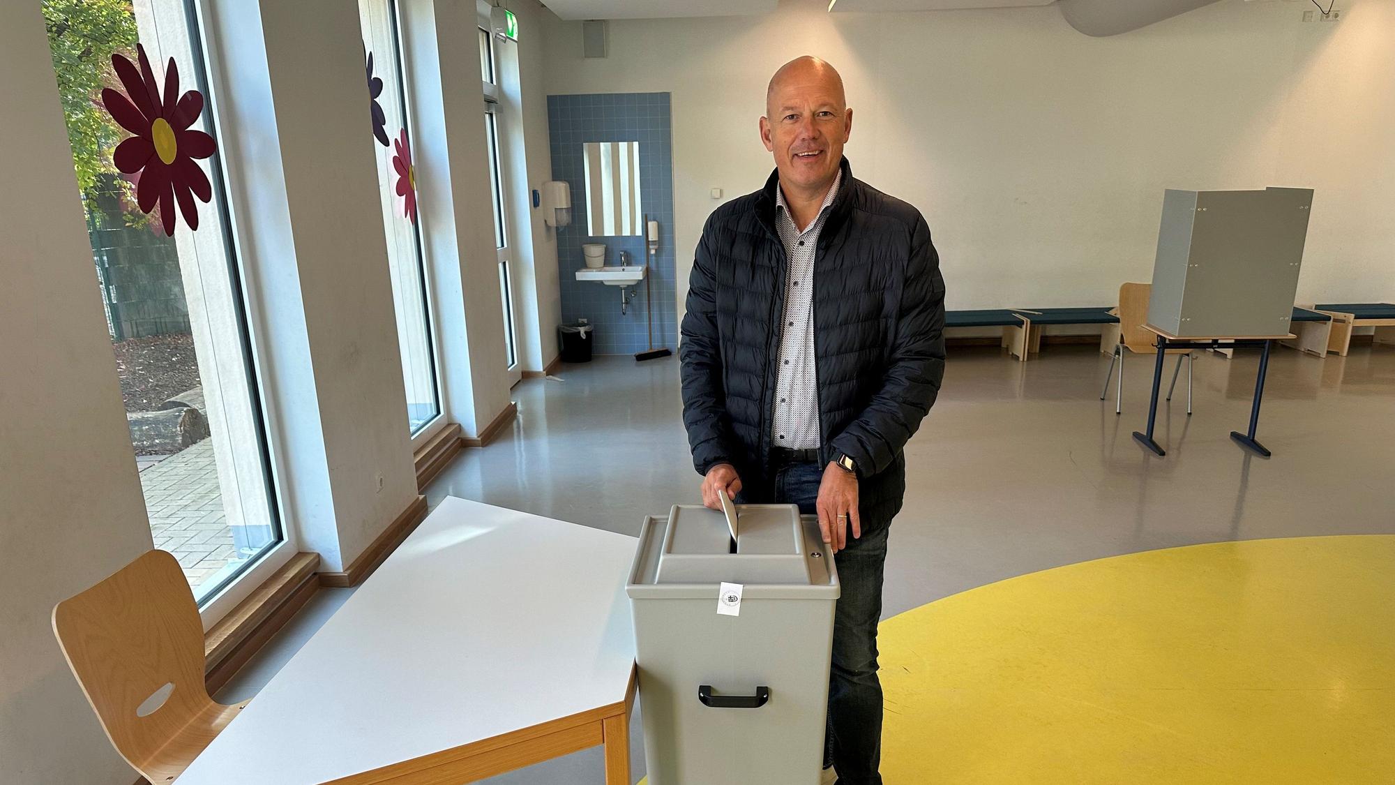 Zu sehen ist Frank Rock, Landrat des Rhein-Erft-Kreises, wie er einen Zettel in eine Wahlurne einwirft.