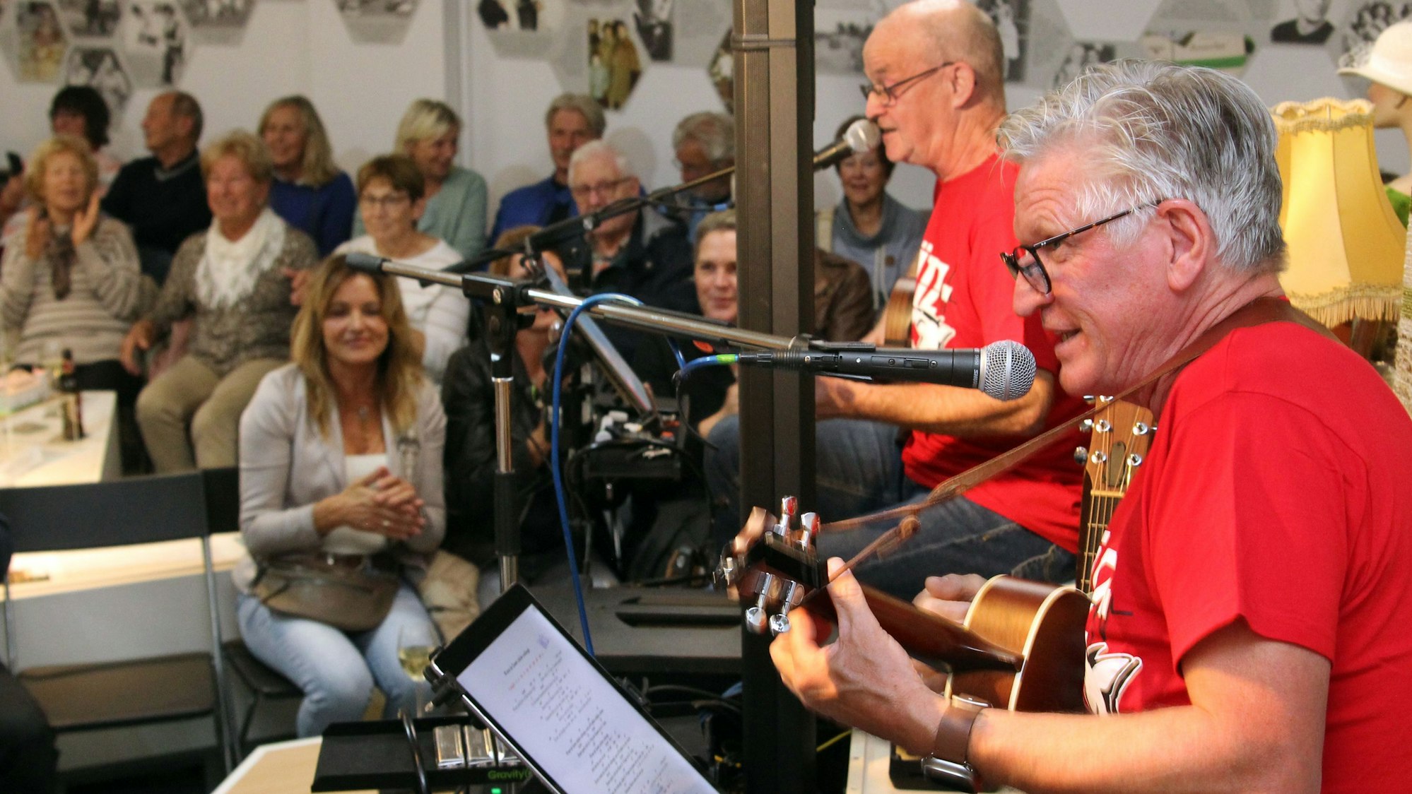 Das Bild zeigt mehrere Musiker auf einer Bühne vor Publikum.