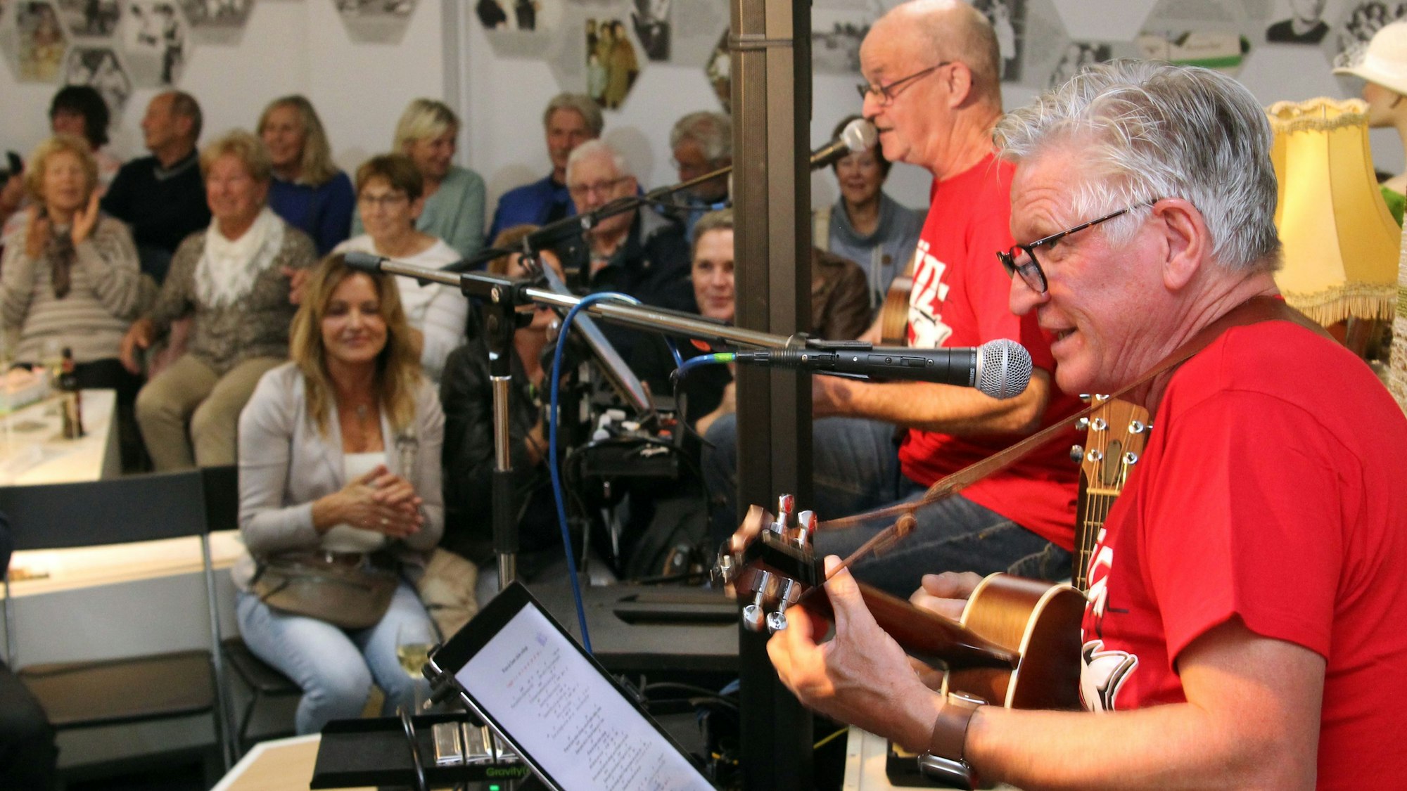 Das Bild zeigt mehrere Musiker auf einer Bühne vor Publikum.