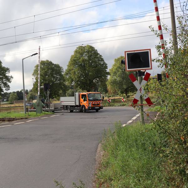Das Bild zeigt einen Bahnübergang im Grünen.