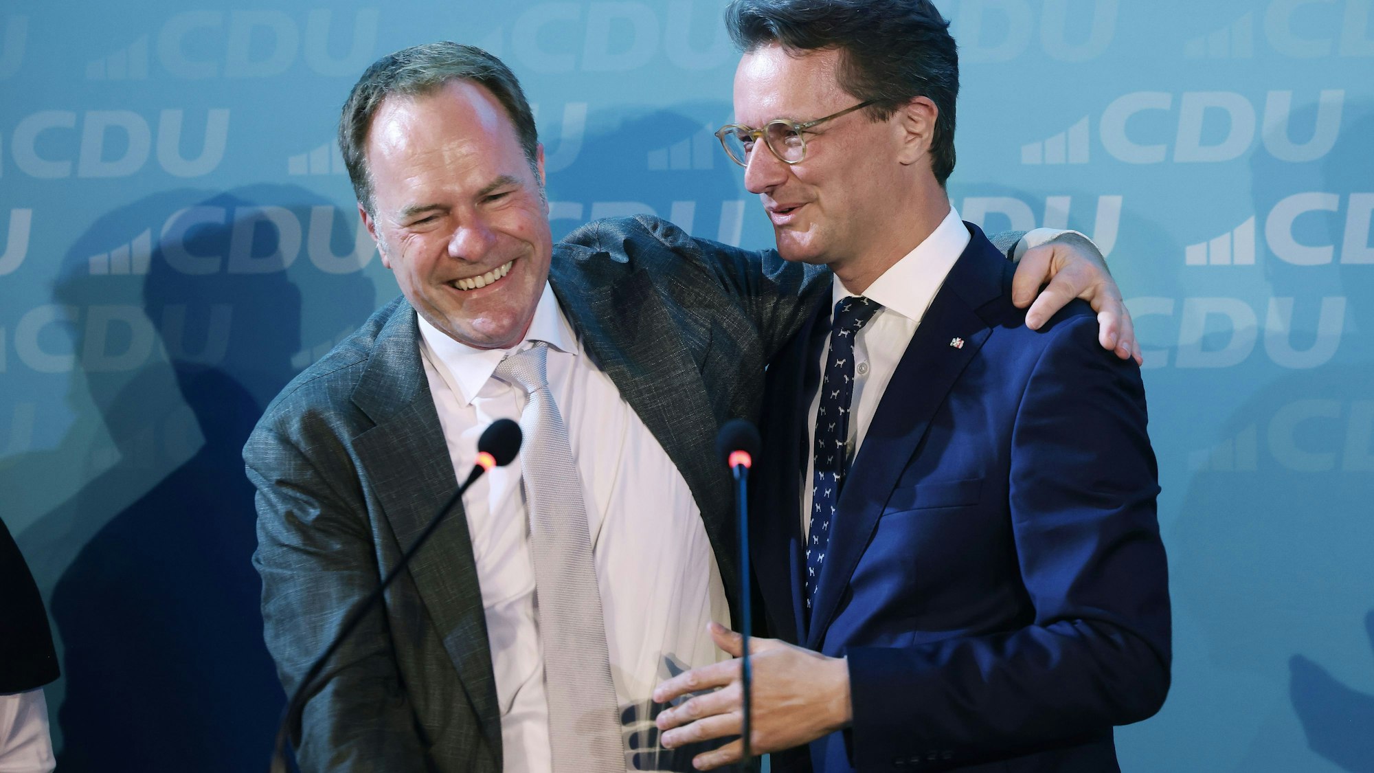 Düsseldorfs Oberbürgermeister Stephan Keller (CDU, l) umarmt Hendrik Wüst (CDU), Ministerpräsident von Nordrhein-Westfalen, am Wahlabend beim CDU-Kreisverband Düsseldorf.