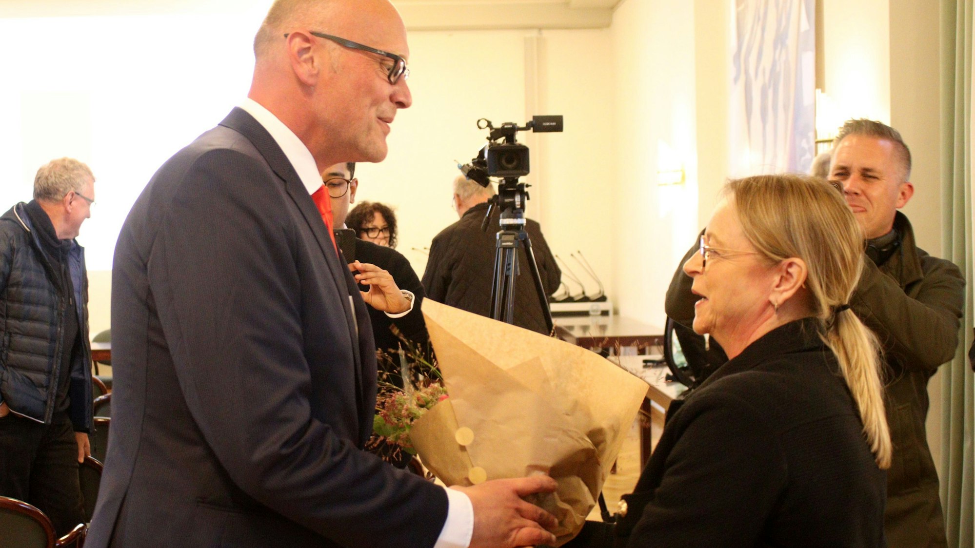 Die bisherige Bad Münstereifeler Bürgermeisterin Sabine Preiser-Marian überreicht ihrem gewählten Nachfolger Sebastian Glatzel einen Blumenstrauß.