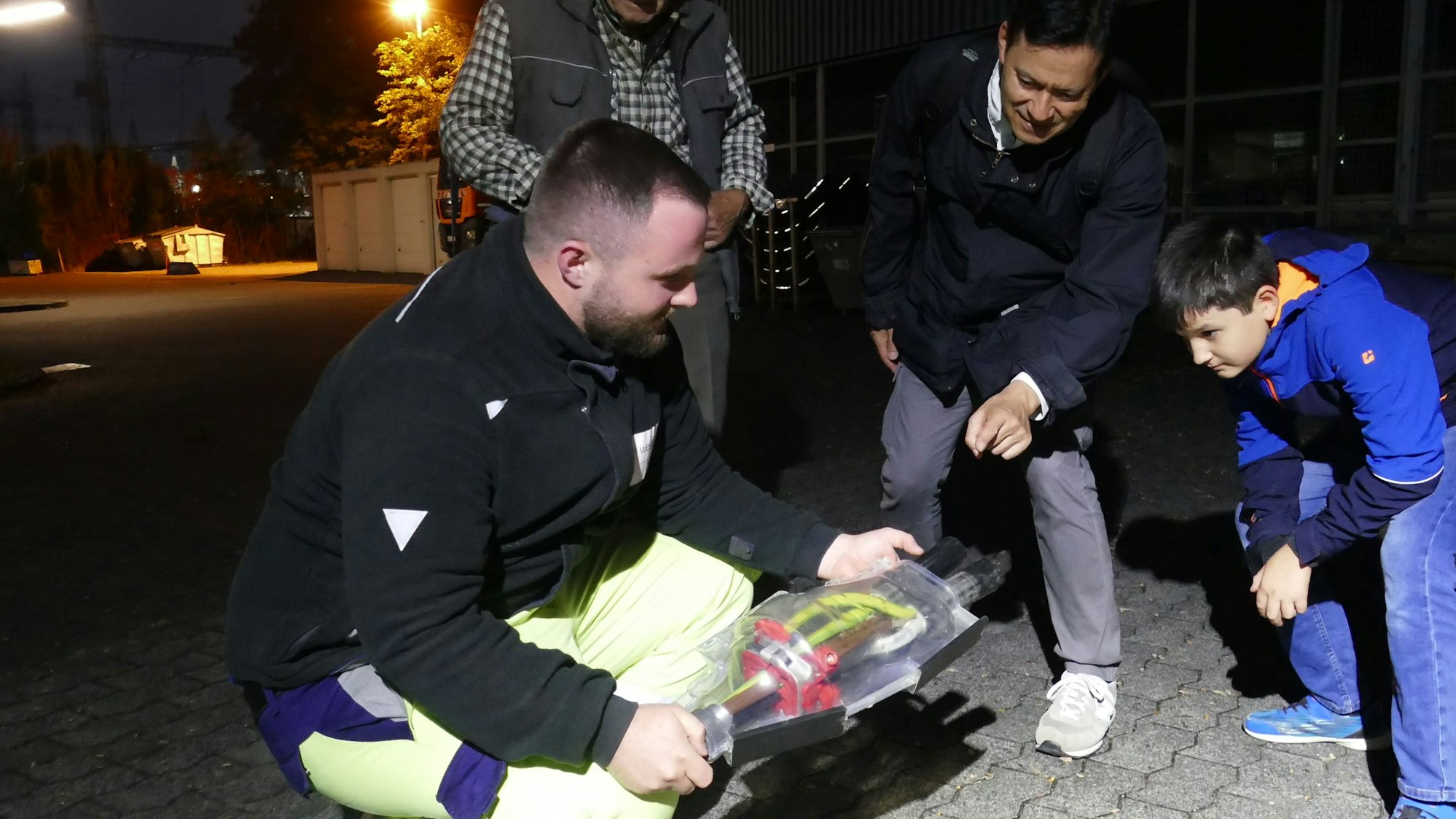 Ein Mann und ein Junge schauen sich ein technisches Bauteil an.