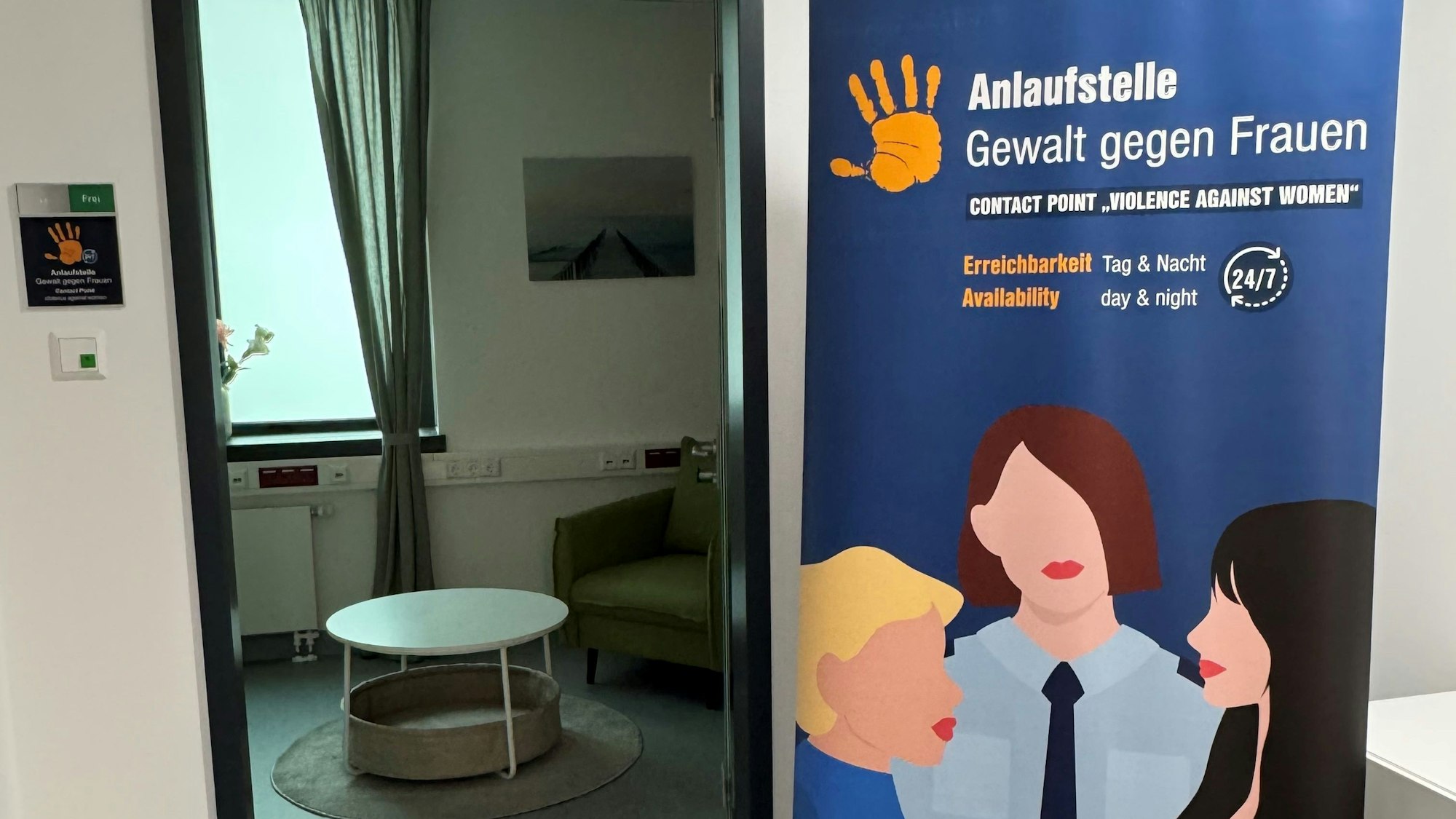 Bild der neuen Anlaufstelle "Gewalt gegen Frauen" mit großem Plakat vor einem Gesprächszimmer