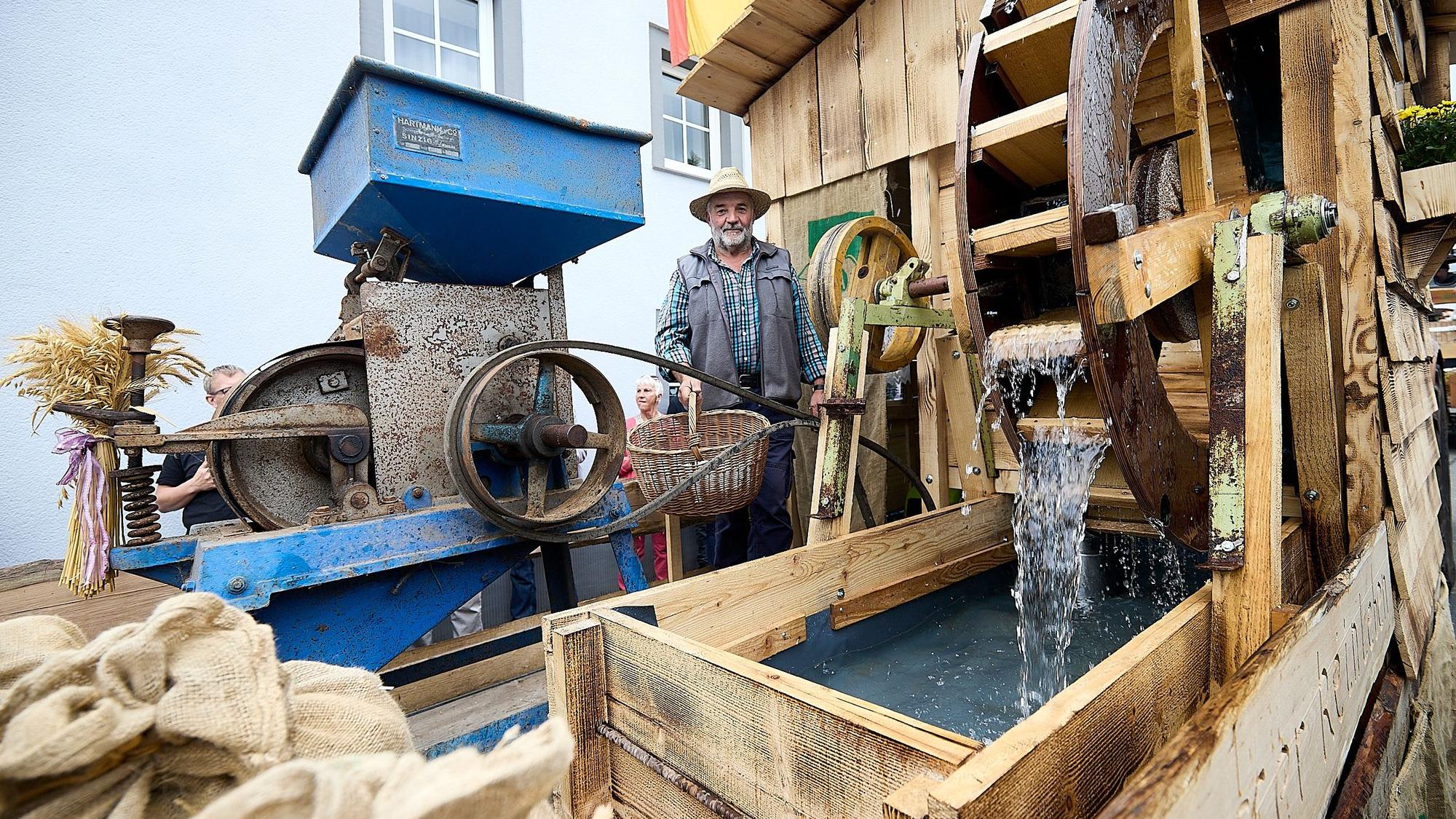 Michael Meuser steht auf seinem Wagen. Er hat darauf eine Wassermühle gebaut.