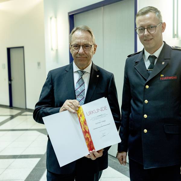 Jochen Hagt nimmt die Urkunde von Julian Seeger entgegen.