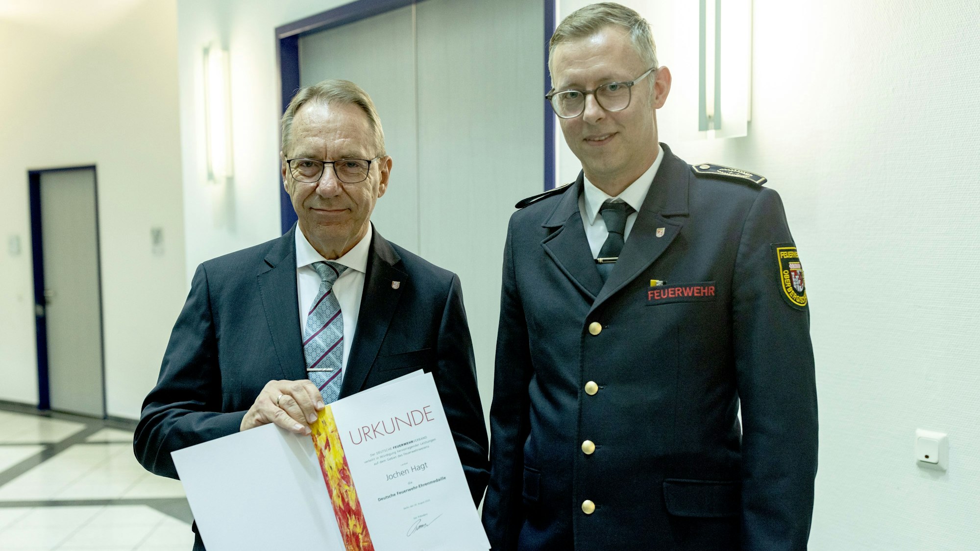 Jochen Hagt nimmt die Urkunde von Julian Seeger entgegen.