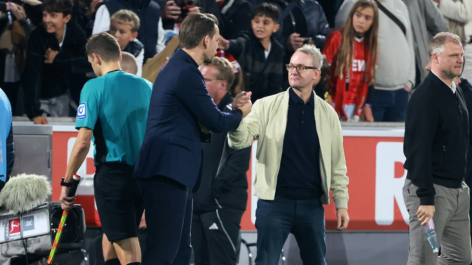 Thomas Kessler und Alexander Wehrle begrüßen sich am Spielfeldrand in Köln.