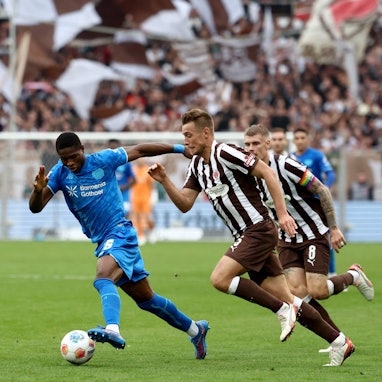 (L-R) Bayer Leverkusen's Cameroonian forward #35 Christian Kofane, St Pauli's German defender #05 Hauke Wahl and St Pauli's Swedish defender #08 Eric Smith vie for the ball during the German first division Bundesliga football match between FC St Pauli and Bayer 04 Leverkusen in Hamburg, northern Germany on September 27, 2025. (Photo by Ibrahim OT / AFP) / DFL REGULATIONS PROHIBIT ANY USE OF PHOTOGRAPHS AS IMAGE SEQUENCES AND/OR QUASI-VIDEO