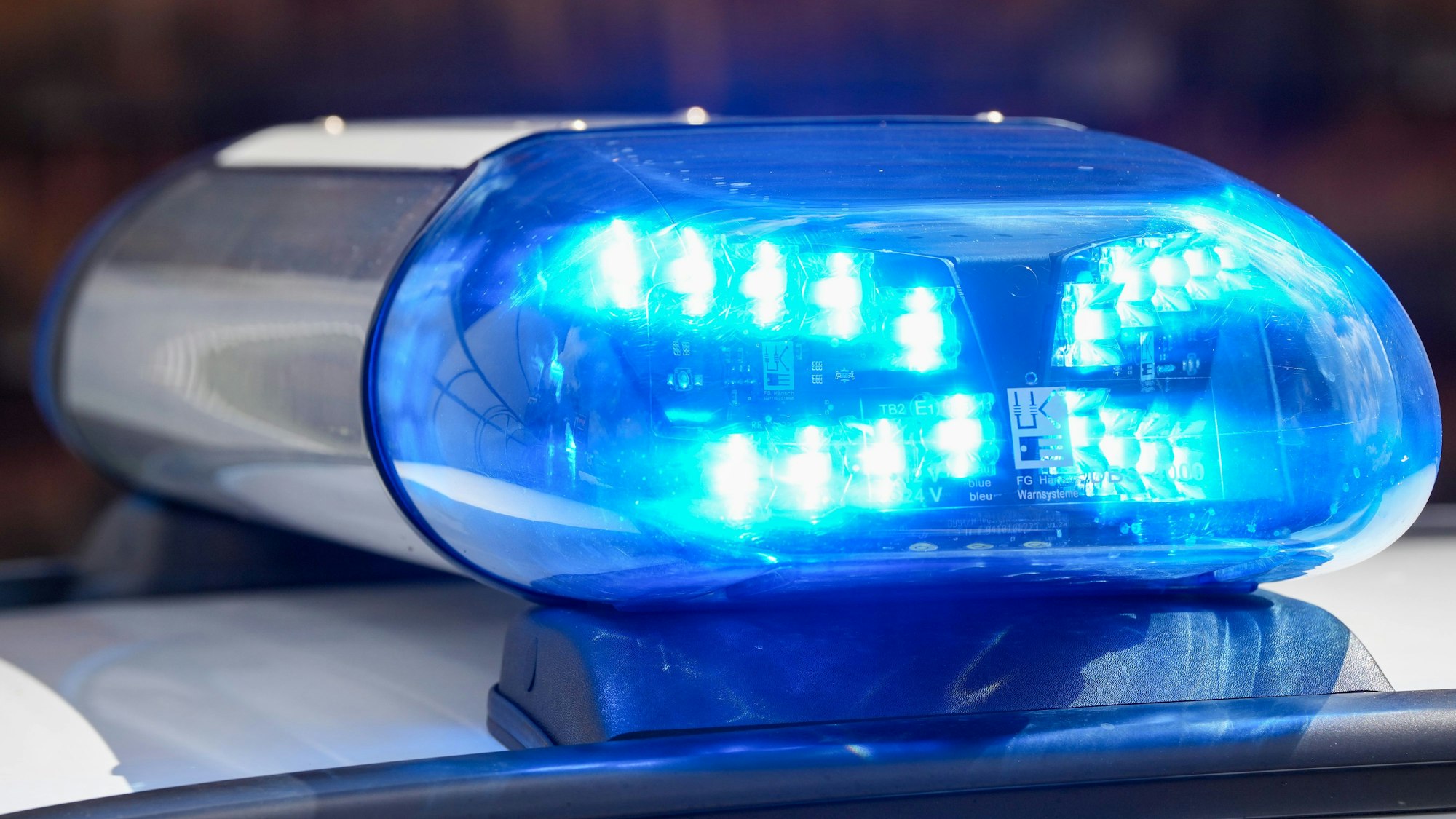 Ein Blaulicht auf einem Polizeifahrzeug leuchtet.