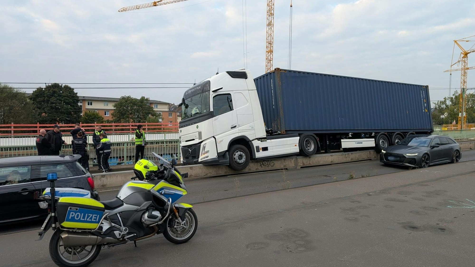 Ein Lkw ist aus noch ungeklärter Ursache auf den betonierten Fahrbahnrand geraten, der die Straße von den Bahnschienen abgrenzt.