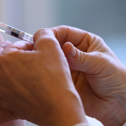 Eine Ärztin impft mit dem saisonalen Wirkstoff gegen die Grippe.