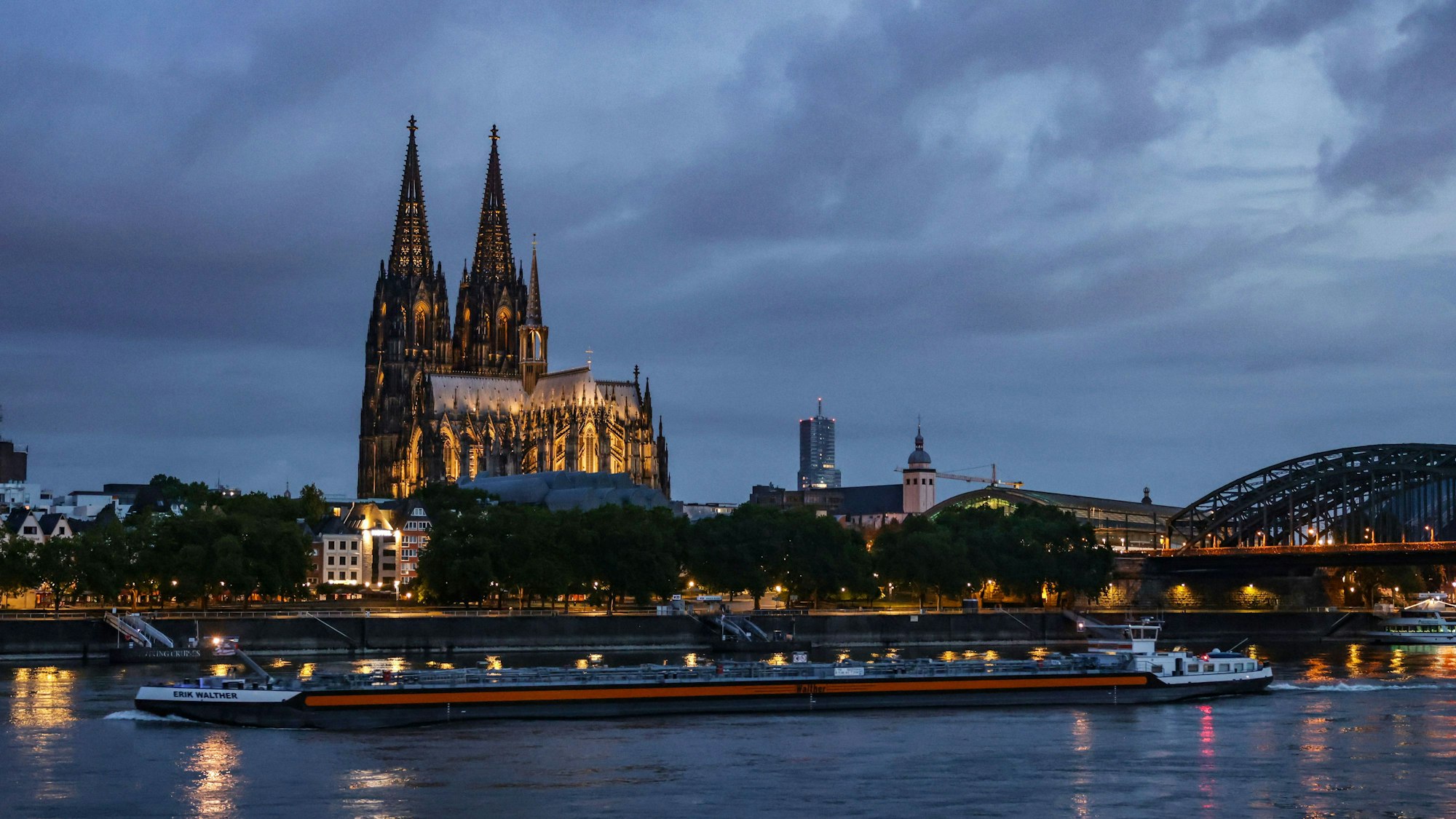Ein Binnenschiff fährt am Morgen am Dom vorbei über den Rhein. (Symbolbild)