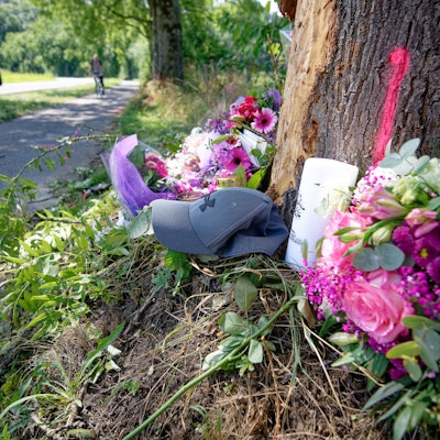 Blumen, Kerzen und eine Mütze liegen an einer Unfallstelle bei Monheim am Rhein.