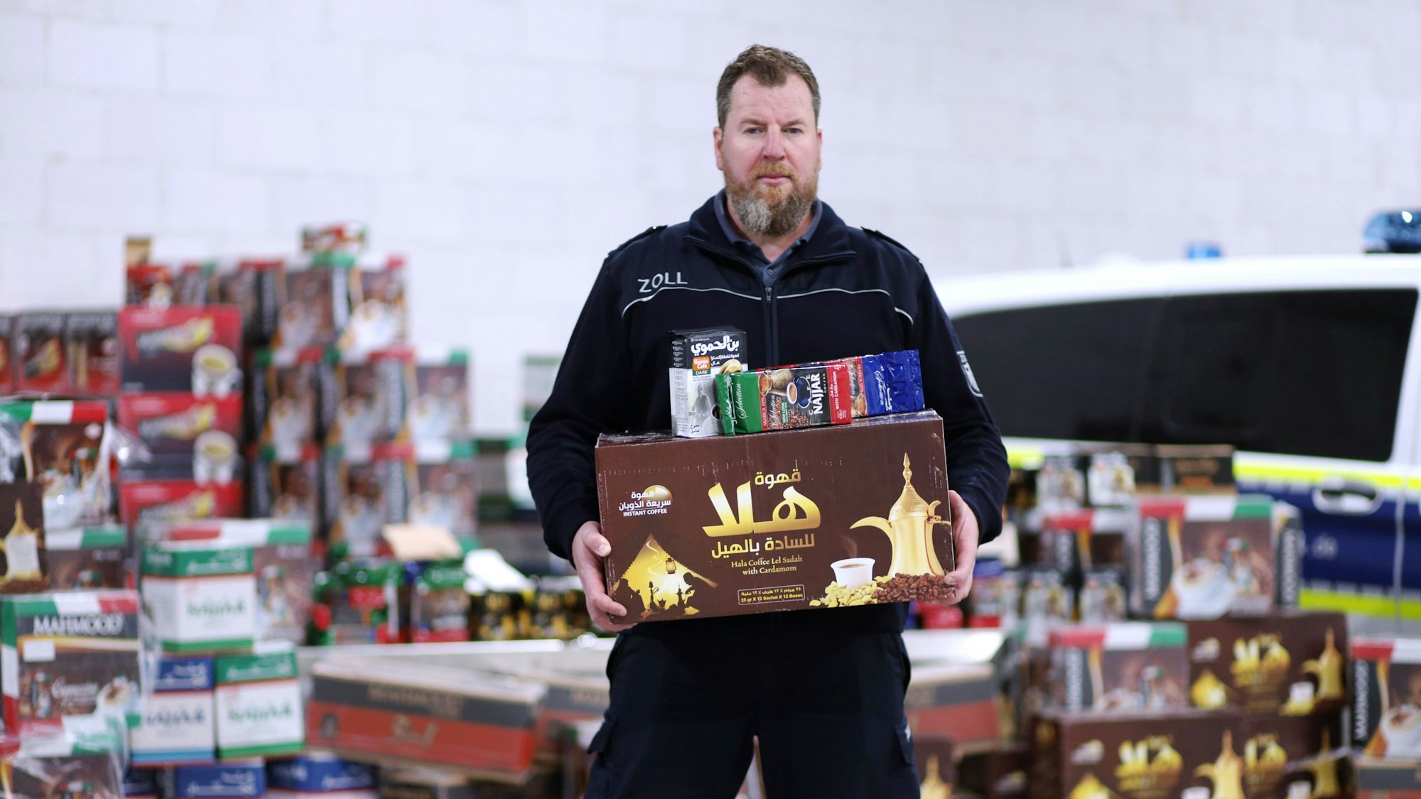 Jens Ahland vom Hauptzollamt Köln präsentiert den sichergestellten Kaffee in einer Lagerhalle.