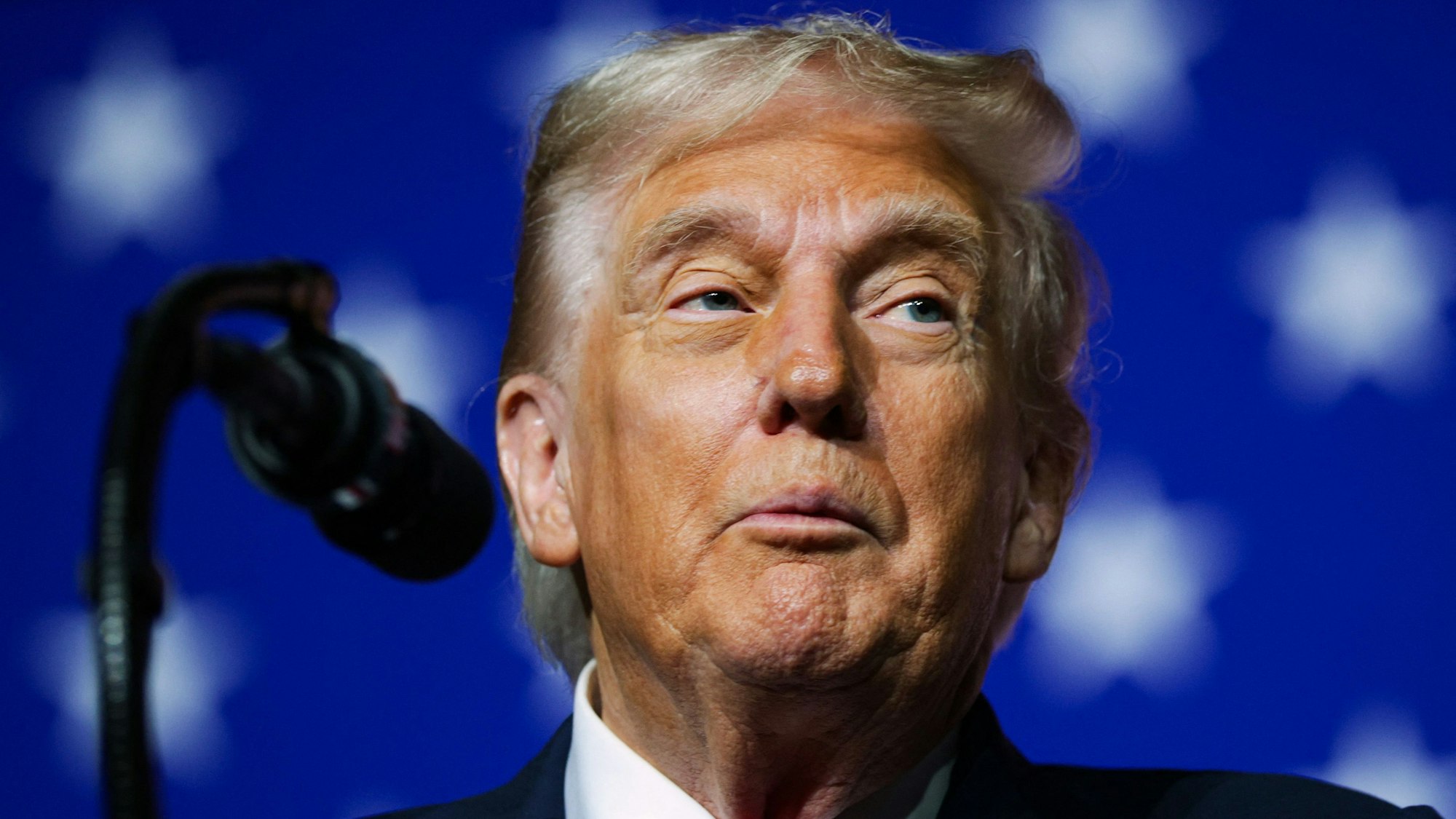 US-Präsident Donald Trump steht auf der Bühne, vor ihm ist ein Mikrofon positioniert.