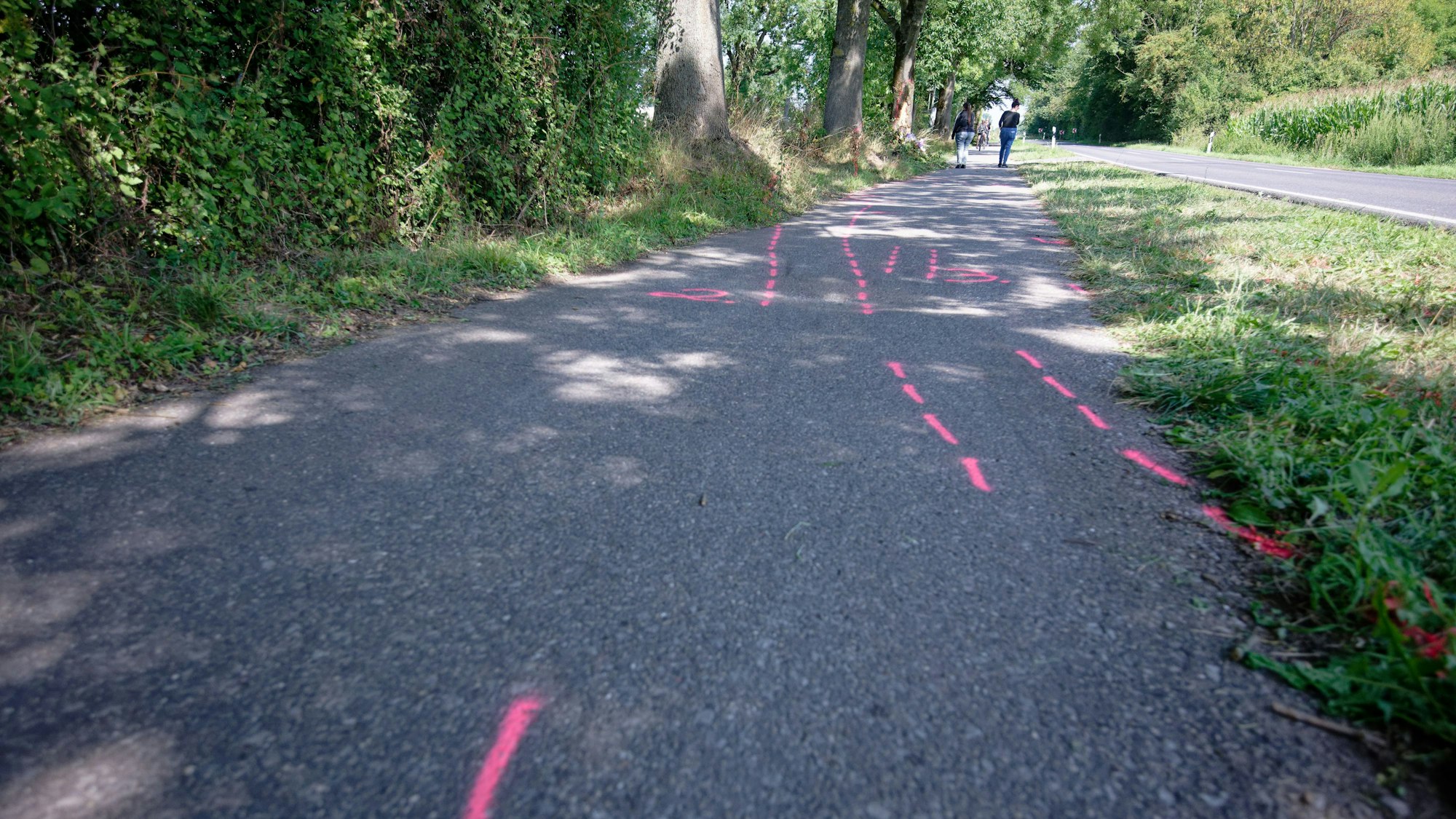 Rote Markierungen der Spurensicherung zeigen an einer Unfallstelle zwischen Monheim den Weg des Unfallwagens.