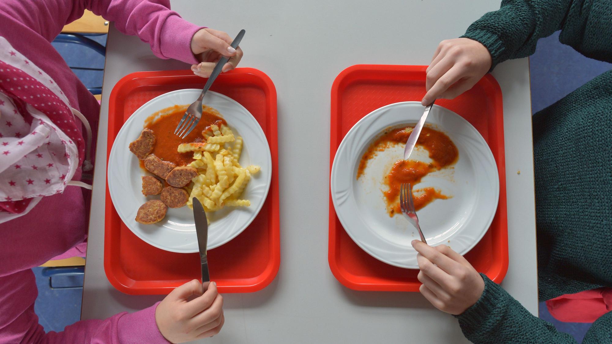 Schüler nehmen in der Schulpause eine warme Mahlzeit zu sich.