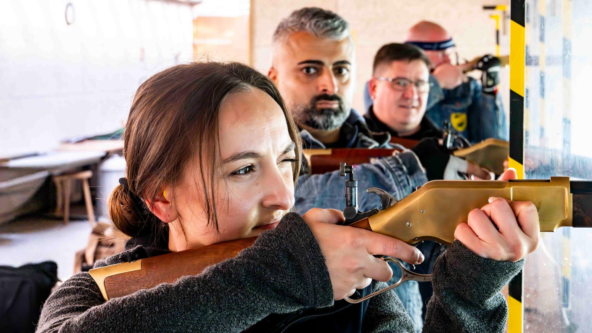 Elena Kapp hat ein Auge geschlossen und schaut konzentriert durch die Zielvorrichtung an einem Gewehr.
