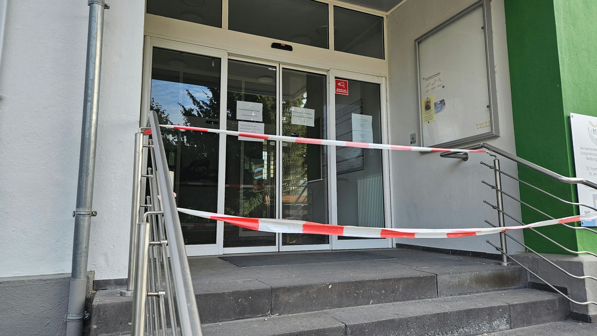 Zu sehen ist der mit Flatterband gesperrte Eingang des einstigen Krankenhauses in Bedburg.