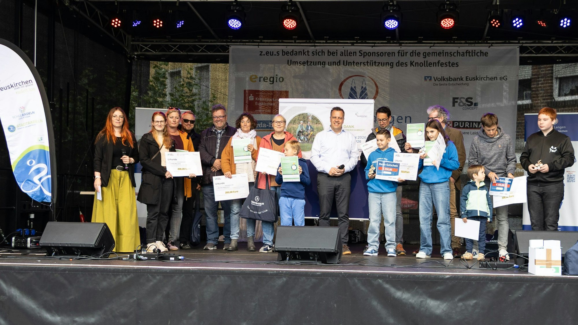 Auf einer Bühne stehen Kinder, Jugendliche und Erwachsene, die Preise und Urkunden vor sich halten.