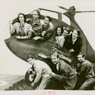 Eine Gruppe posiert in einem Helikopter aus Pappe.