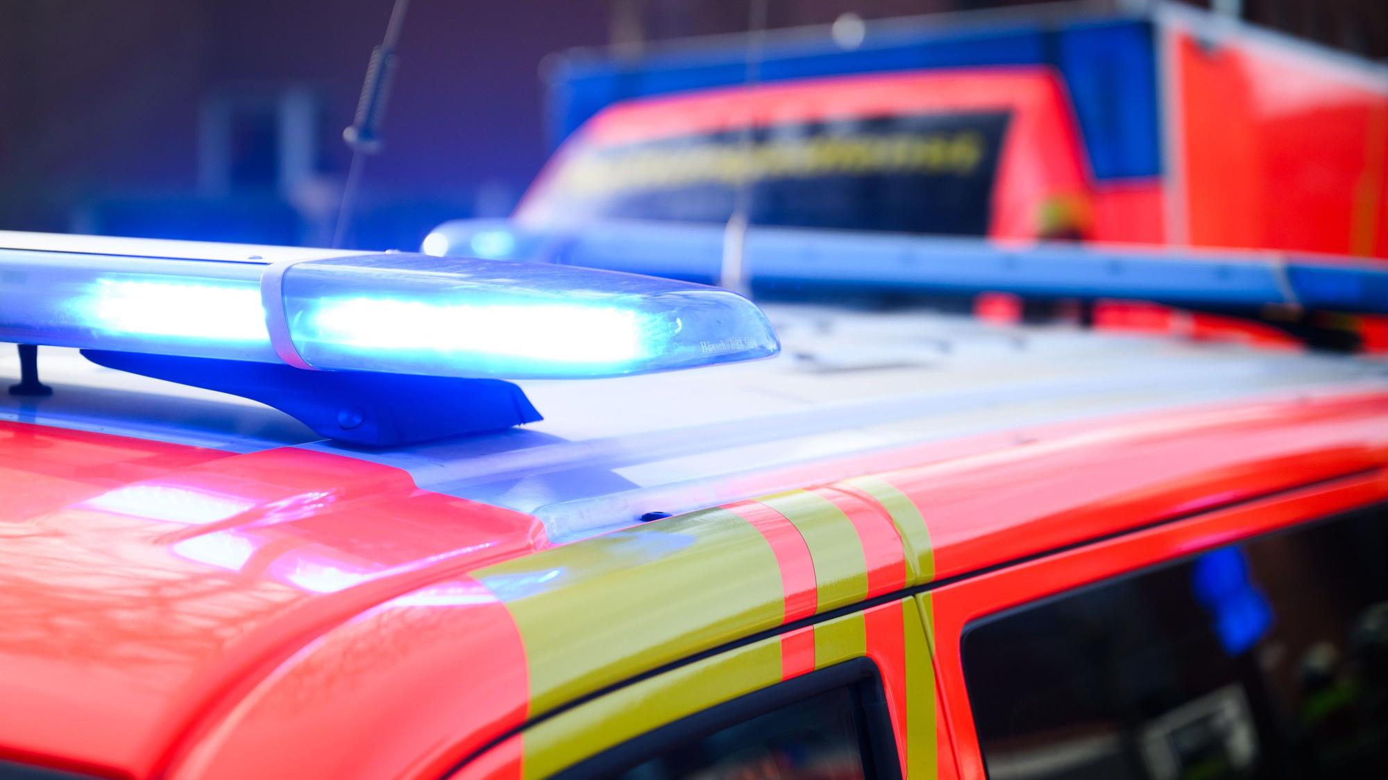 Blaulichter leuchten an einer Einsatzstelle auf einem Notarzt-Fahrzeug und einem Rettungswagen.