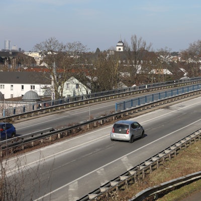 Autos fahren über eine Brücke, im Hintergrund die Altstadt von Königswinter.